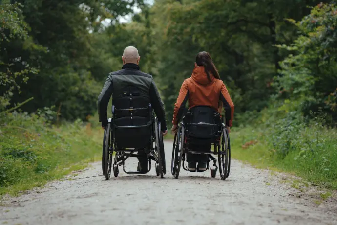 Twee modellen in hun rolstoel in de rolstoeljassen van MOS by Alicia, gefotografeerd van de acchterkant